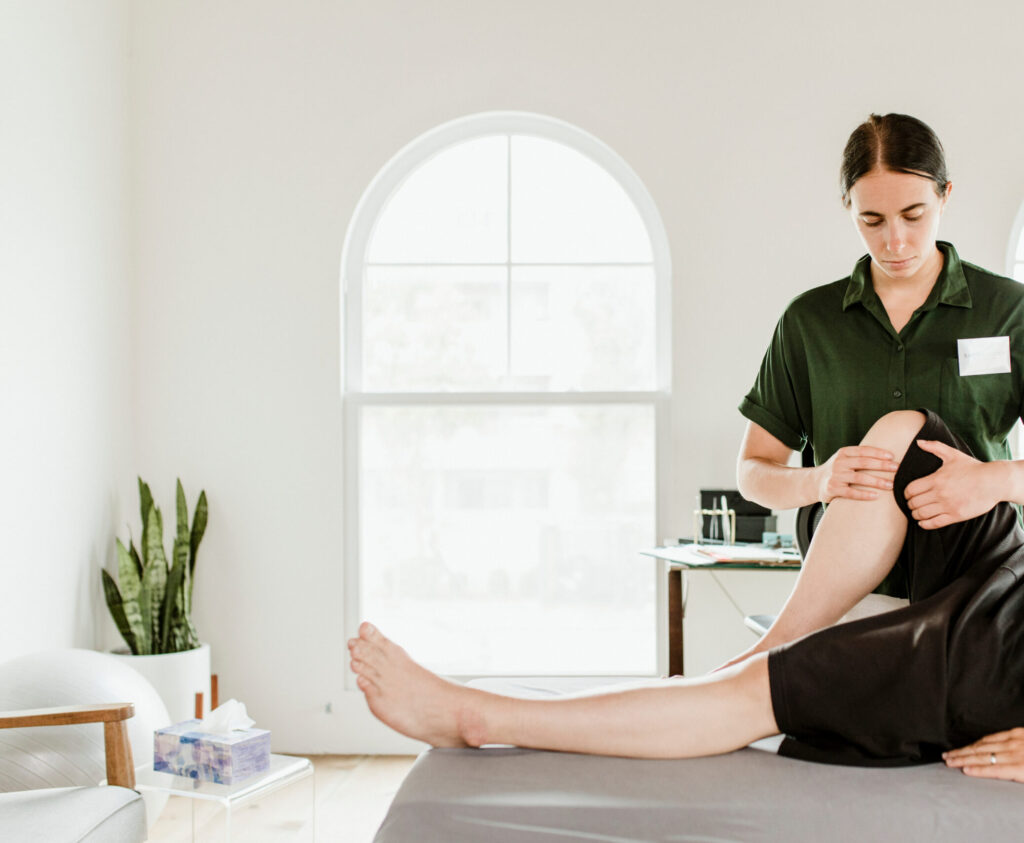 Een man ontvangt een beenmassage van een vrouwelijke fysiotherapeut.